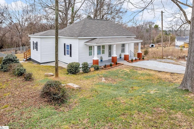 back of property with a lawn and covered porch