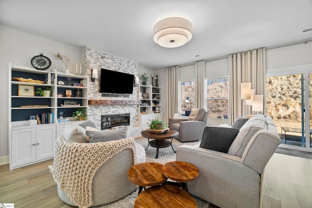 living room with a large fireplace and light hardwood / wood-style floors