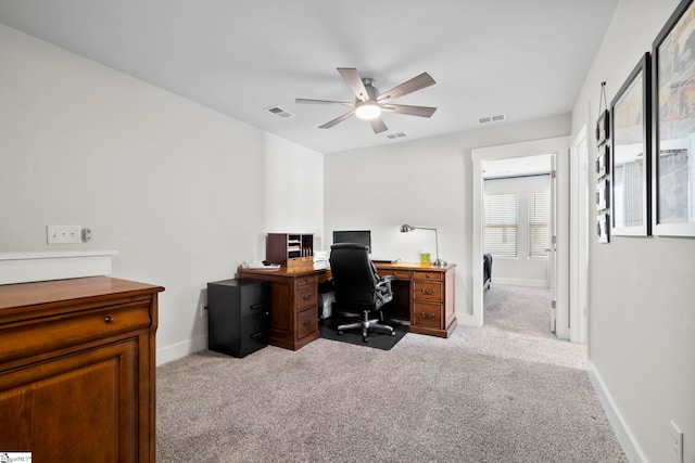 carpeted home office featuring ceiling fan