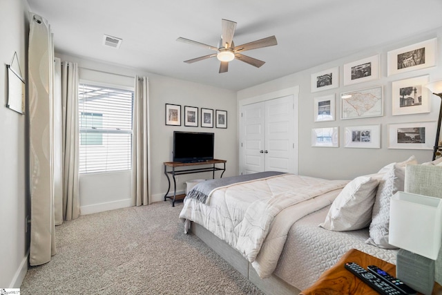 bedroom with light carpet, ceiling fan, and a closet