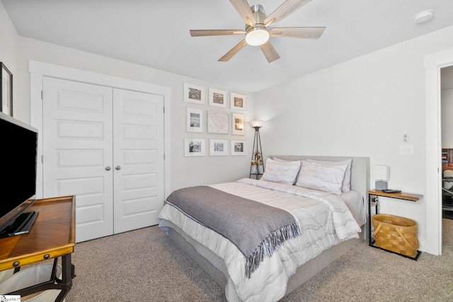 carpeted bedroom featuring ceiling fan and a closet