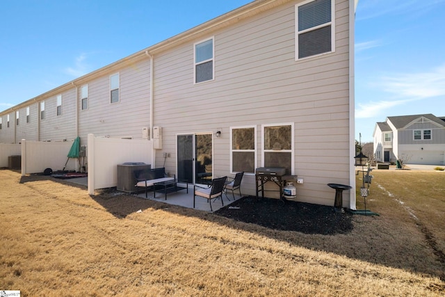 rear view of property with a patio, cooling unit, and a lawn