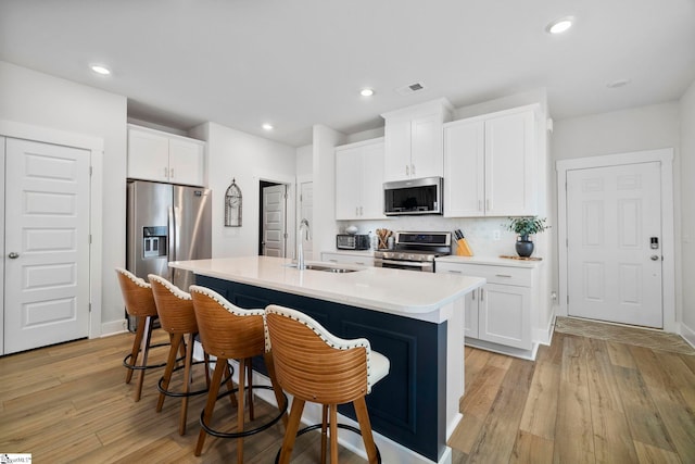 kitchen with appliances with stainless steel finishes, sink, and white cabinets