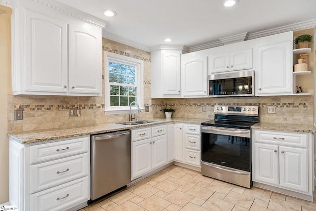 kitchen with white cabinetry, appliances with stainless steel finishes, sink, and decorative backsplash