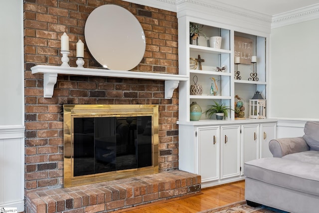 living room with ornamental molding, a fireplace, and light hardwood / wood-style floors