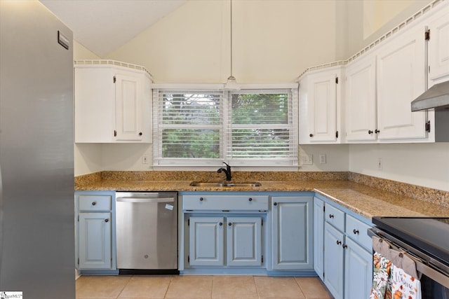 kitchen featuring sink, light tile patterned floors, white cabinetry, stainless steel appliances, and vaulted ceiling