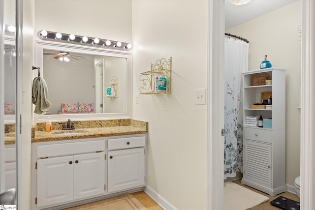 bathroom with toilet, a textured ceiling, vanity, ceiling fan, and tile patterned flooring