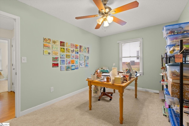 home office with light carpet, a textured ceiling, and ceiling fan