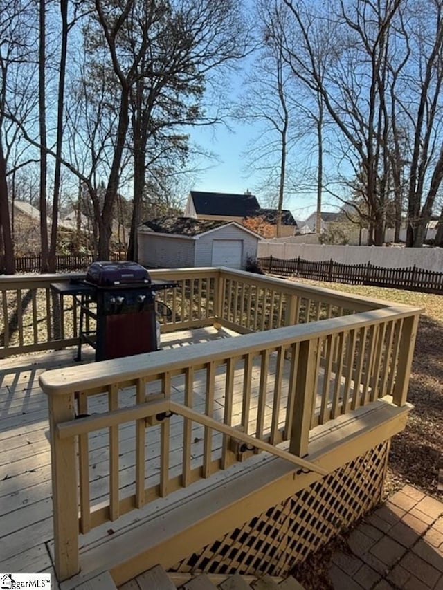 deck with a grill and a storage shed