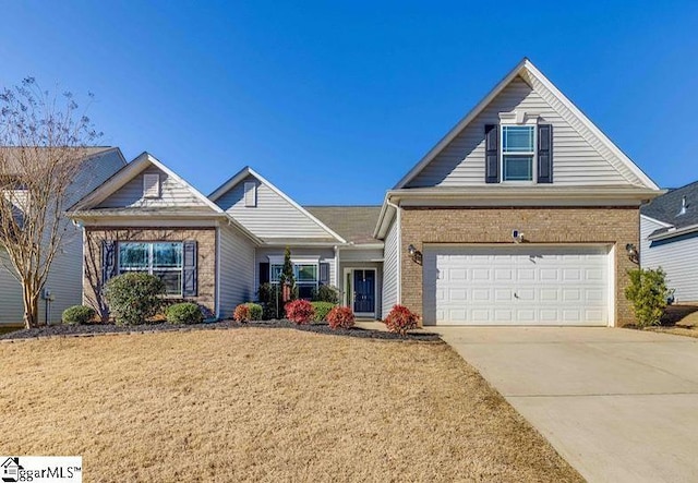 view of front of house with driveway, a garage, a front yard, and brick siding