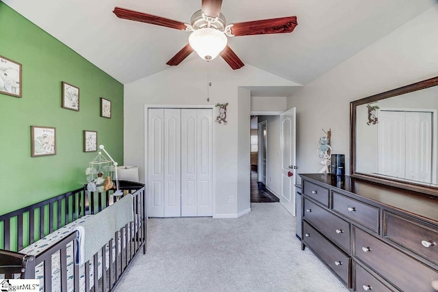 bedroom featuring light carpet, baseboards, lofted ceiling, ceiling fan, and a closet