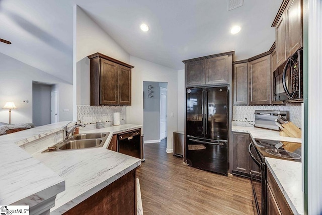 kitchen featuring dark brown cabinetry, visible vents, light wood-style floors, black appliances, and a sink