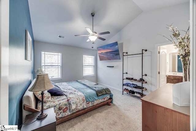 bedroom with visible vents, ceiling fan, ensuite bathroom, carpet, and vaulted ceiling