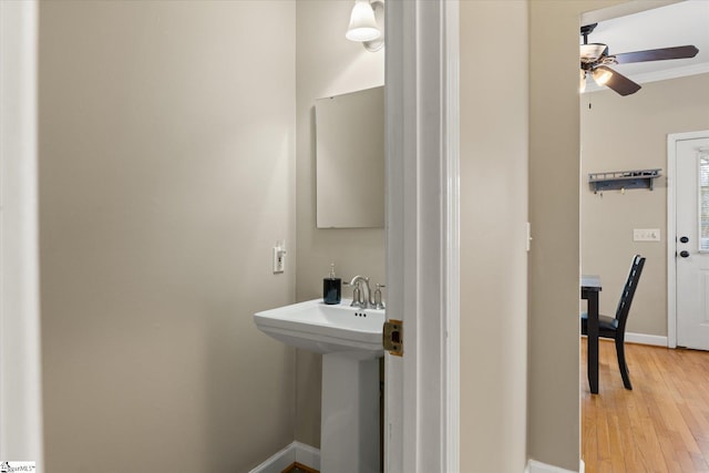 bathroom with hardwood / wood-style flooring, ornamental molding, and ceiling fan