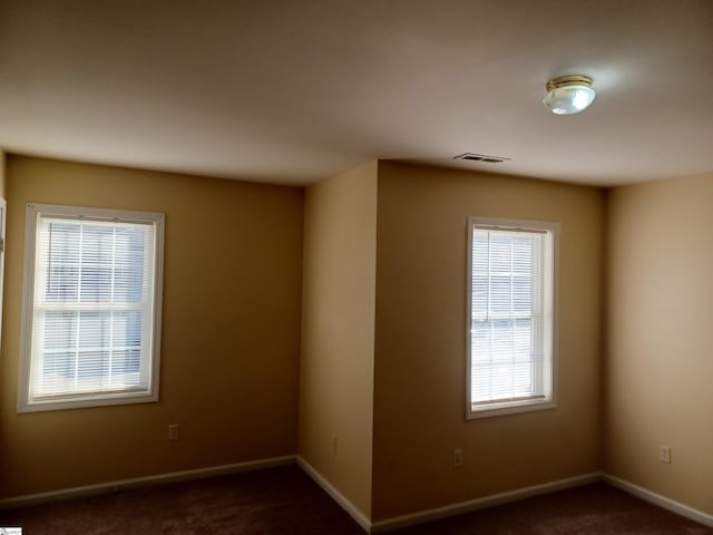 spare room with dark carpet