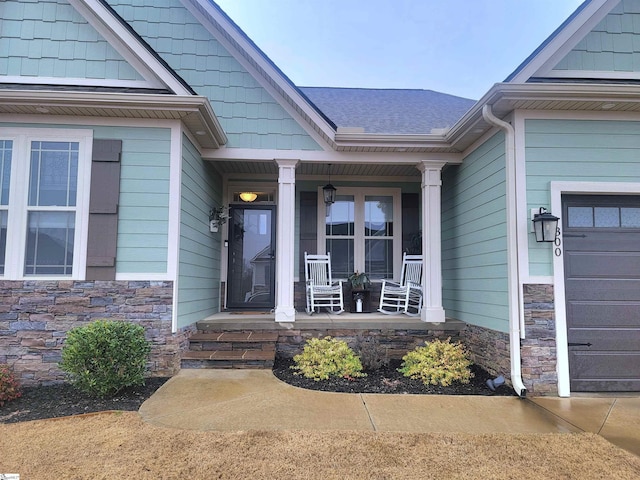 doorway to property with a porch and a garage