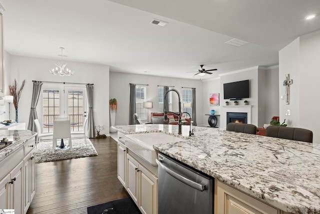 kitchen featuring sink, dark wood-type flooring, dishwasher, hanging light fixtures, and light stone counters