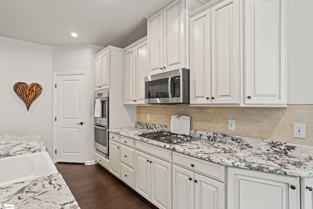 kitchen featuring dark hardwood / wood-style flooring, stainless steel appliances, and white cabinets