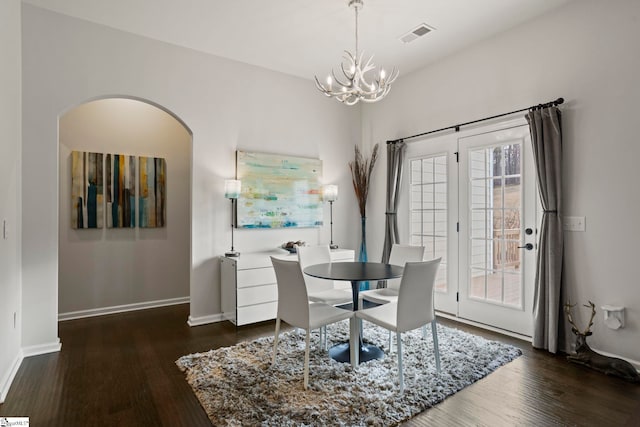 dining area featuring plenty of natural light, dark hardwood / wood-style floors, and a chandelier