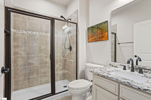 bathroom featuring vanity, toilet, and an enclosed shower