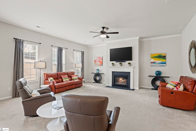 carpeted living room with ornamental molding and ceiling fan