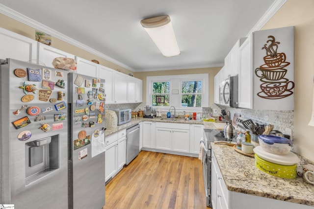 kitchen featuring sink, appliances with stainless steel finishes, light stone counters, white cabinets, and decorative backsplash