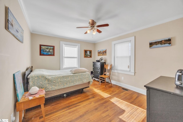 bedroom featuring crown molding, ceiling fan, hardwood / wood-style floors, and multiple windows