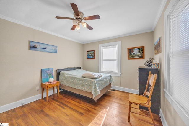 bedroom with crown molding, wood-type flooring, and ceiling fan