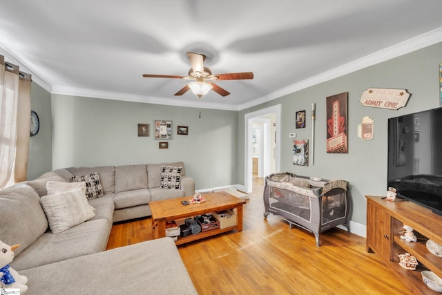 living room with crown molding, wood-type flooring, and ceiling fan