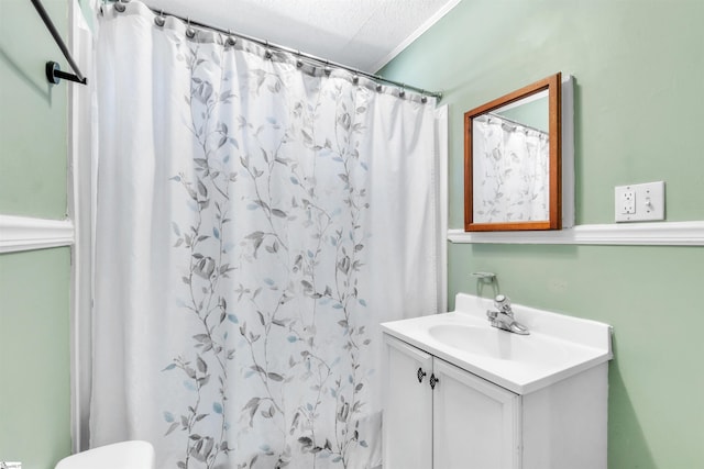 bathroom with vanity, curtained shower, toilet, and a textured ceiling