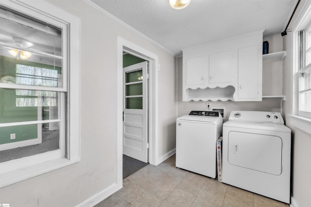 clothes washing area with crown molding, cabinets, washer and dryer, light tile patterned floors, and a textured ceiling