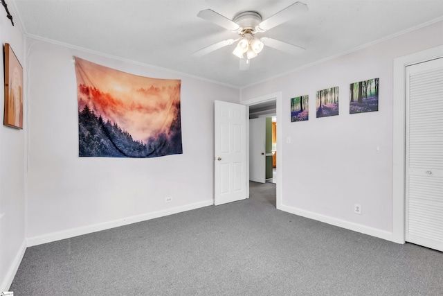 unfurnished bedroom with crown molding, a closet, ceiling fan, and dark colored carpet