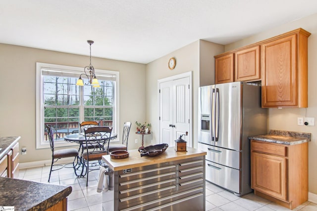 kitchen featuring light tile patterned floors, decorative light fixtures, stainless steel fridge, and a chandelier