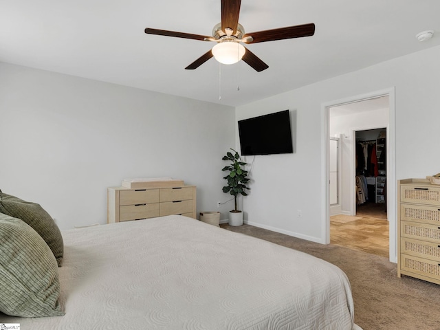 bedroom featuring ceiling fan, light colored carpet, and a spacious closet