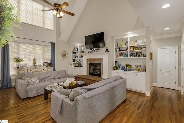 living room with built in shelves, dark wood-type flooring, high vaulted ceiling, and ceiling fan