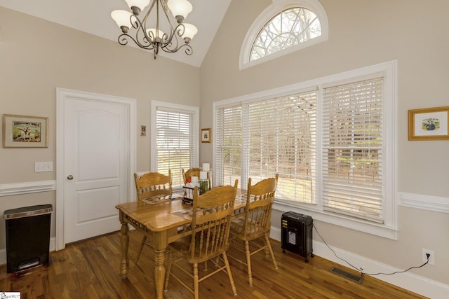 dining space with a notable chandelier, high vaulted ceiling, and dark hardwood / wood-style floors