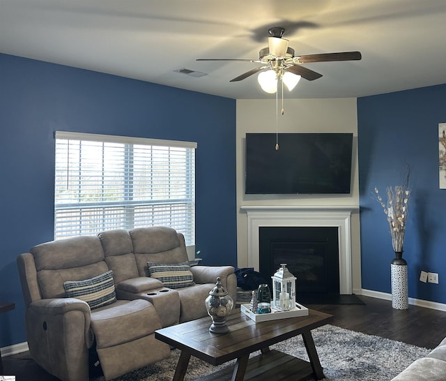 living room featuring ceiling fan and dark hardwood / wood-style flooring