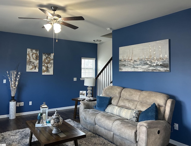 living room featuring dark wood-type flooring and ceiling fan