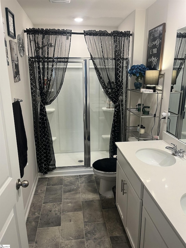 bathroom featuring vanity, toilet, and walk in shower