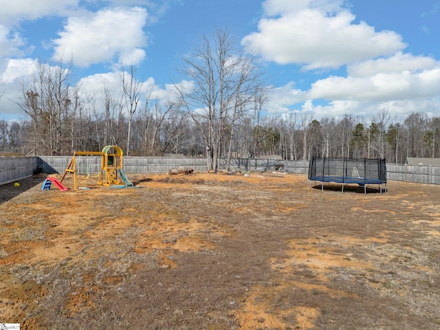 view of yard with a trampoline and a playground