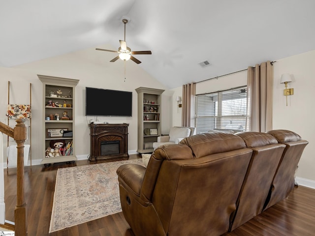 living room with ceiling fan, vaulted ceiling, built in features, and dark hardwood / wood-style flooring