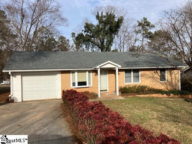 single story home with a garage and a front lawn