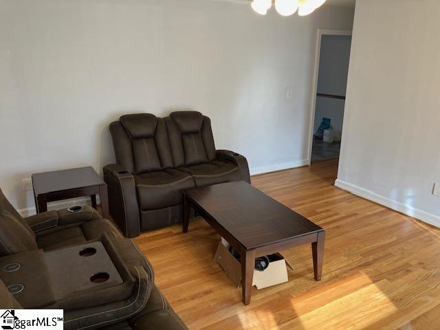 living room with a chandelier and light wood-type flooring