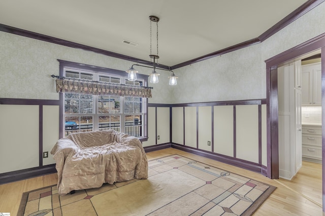 sitting room with ornamental molding and light hardwood / wood-style flooring