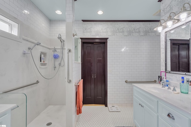 bathroom with tile patterned floors, a shower, crown molding, tile walls, and vanity