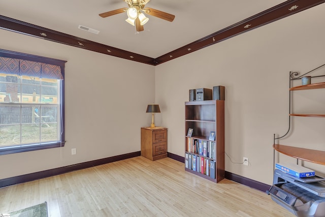 interior space with ceiling fan, crown molding, and light wood-type flooring