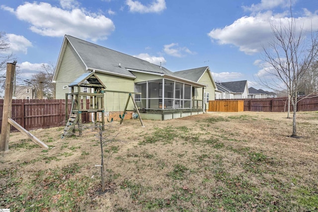 back of house with a sunroom and a playground