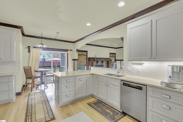 kitchen with white cabinets, sink, kitchen peninsula, and dishwasher