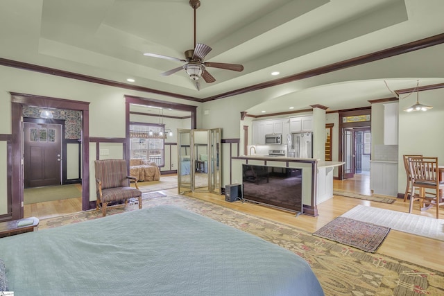 bedroom with sink, stainless steel fridge with ice dispenser, light hardwood / wood-style flooring, ornamental molding, and a raised ceiling