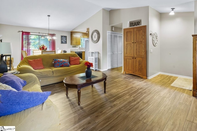 living room with hardwood / wood-style flooring and vaulted ceiling